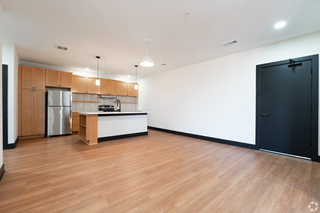 A kitchen with wooden floors and a black door.
