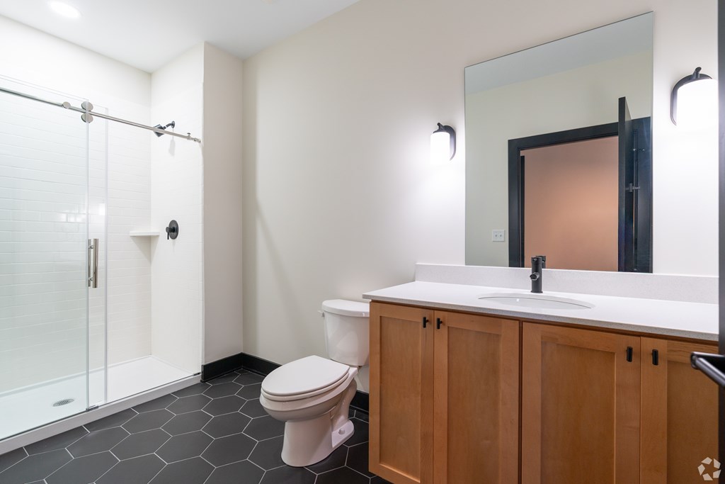 A bathroom with a toilet, sink, and shower.