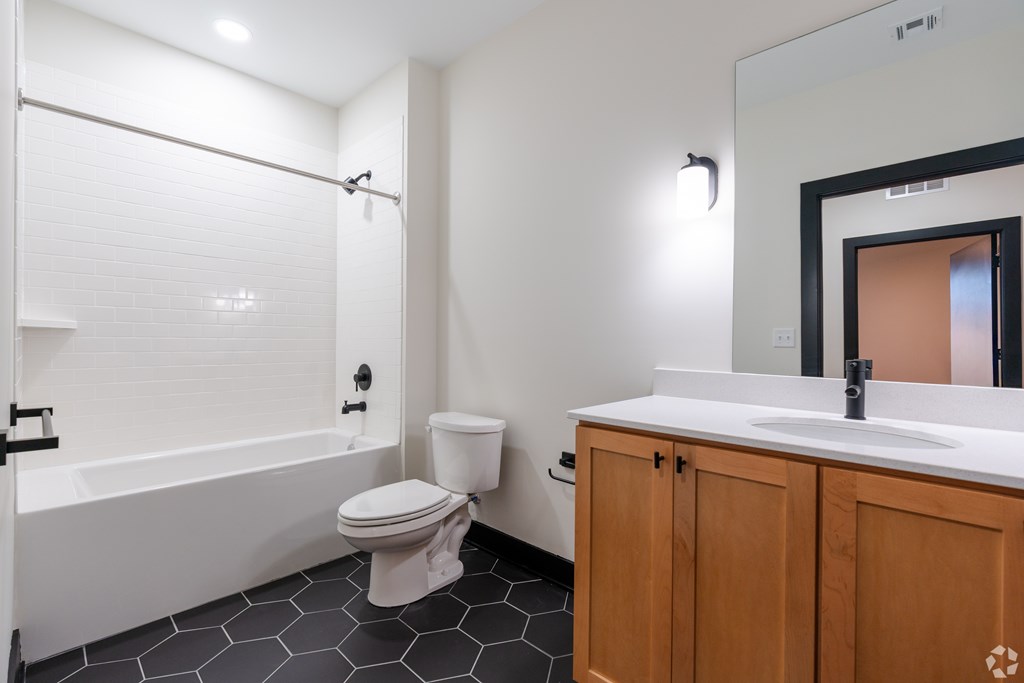 A white bathroom with a toilet, sink, and bathtub.