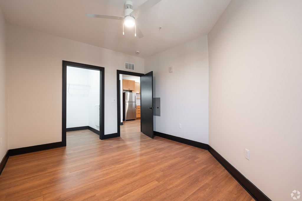 A room with a wooden floor and a ceiling fan.