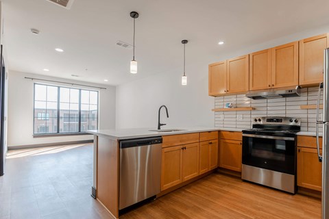 A modern kitchen with wooden cabinets and stainless steel appliances.