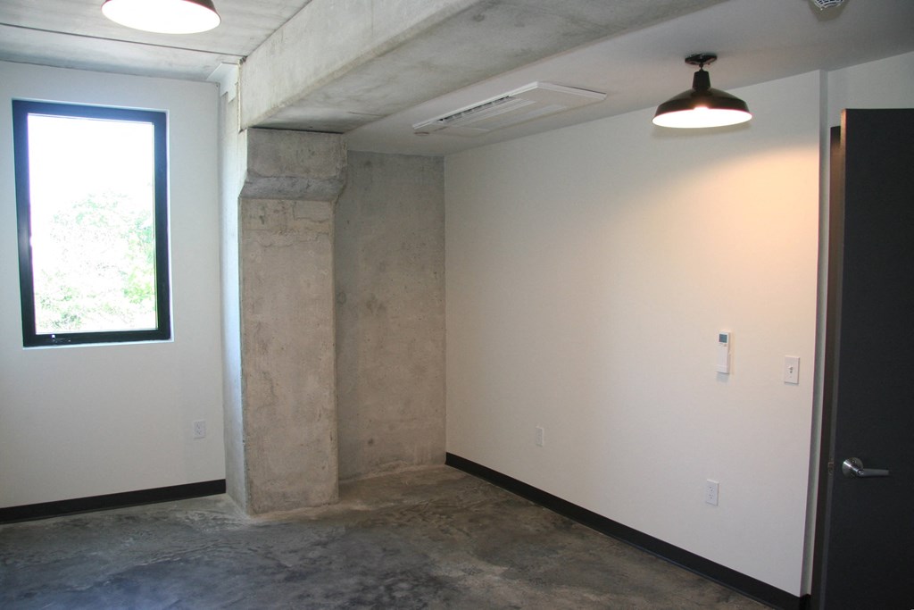 an empty room with a window and a white wall