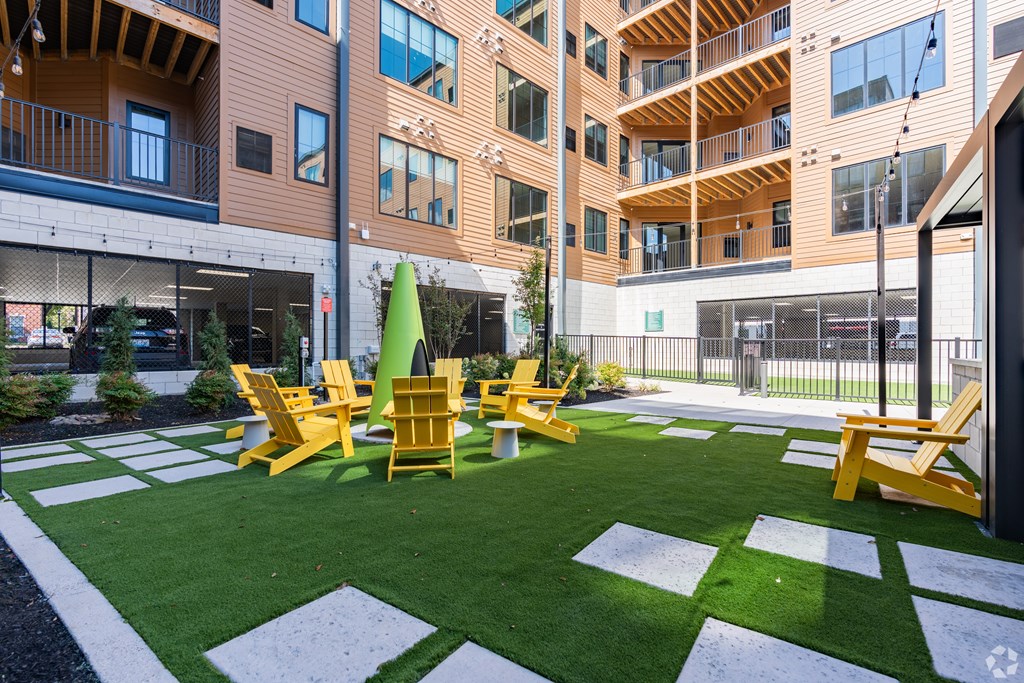 A green lawn with yellow chairs and a white and green striped border.