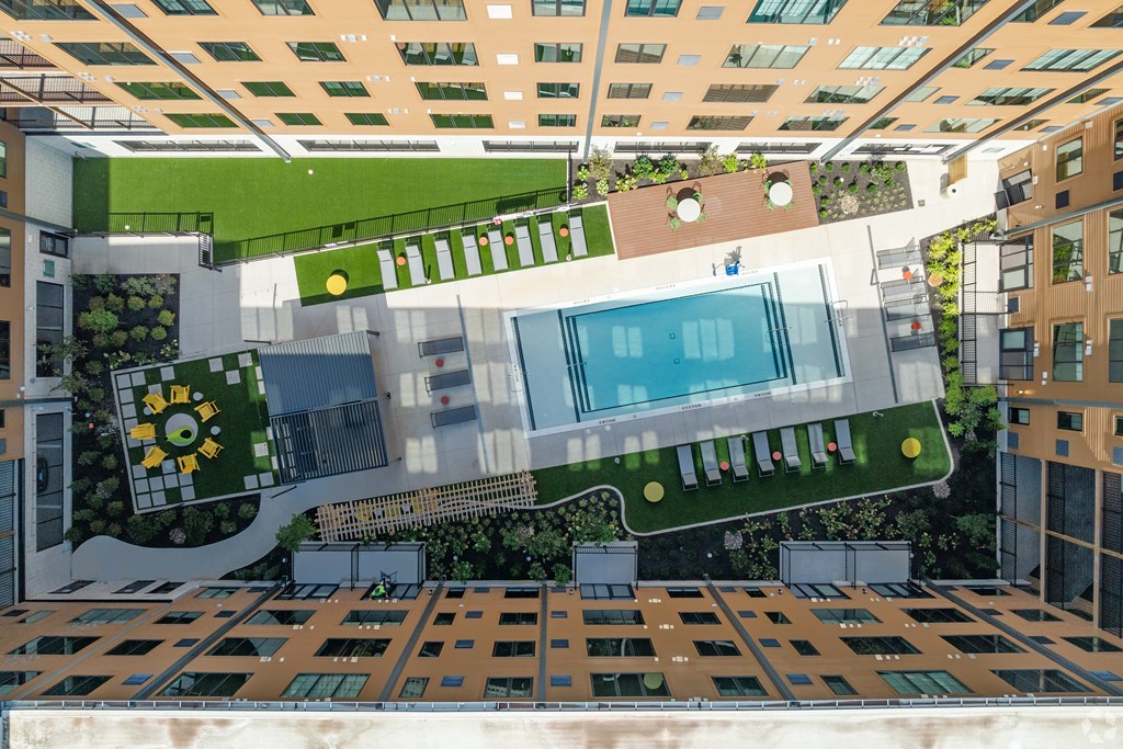 A modern building with a pool and greenery.