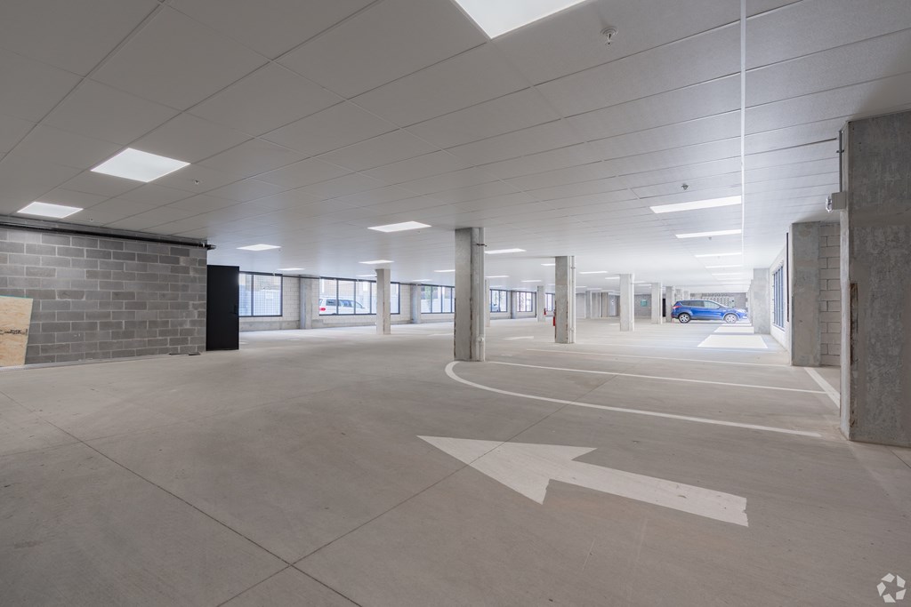 A parking garage with a white arrow on the ground pointing to the right.