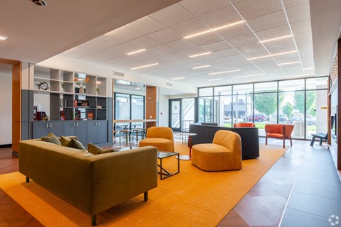 A modern living room with a yellow rug and a sofa.