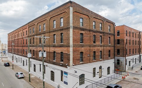 A large brick building with a white section on the bottom.