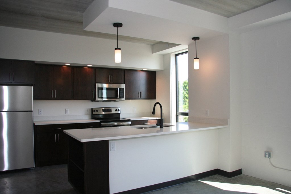 an empty kitchen with a counter top and a refrigerator