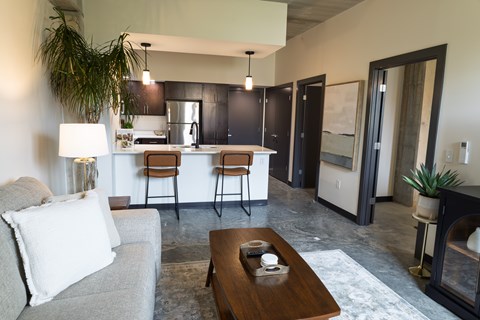 A modern living room with a grey couch and a wooden coffee table.