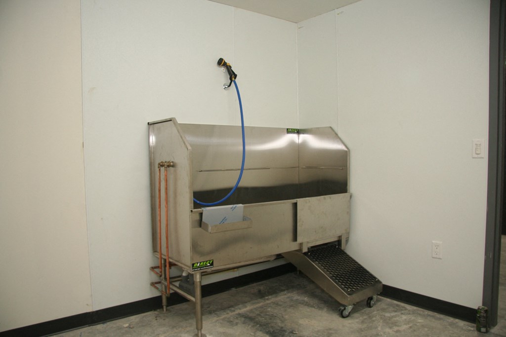 a stainless steel evaporator in a white walled room