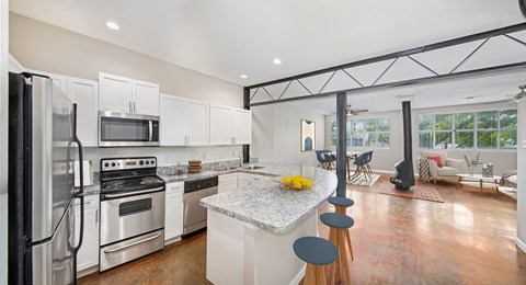a kitchen with white cabinets and a marble counter top