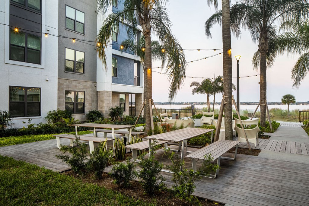 an outdoor patio with benches and palm trees