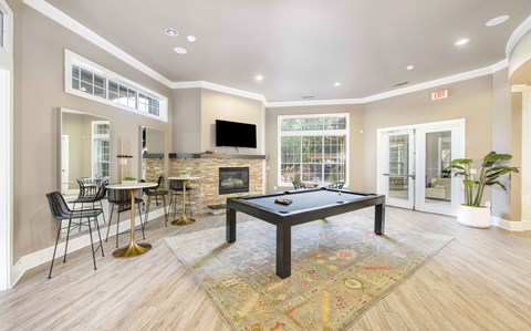 A living room with a pool table and a fireplace.