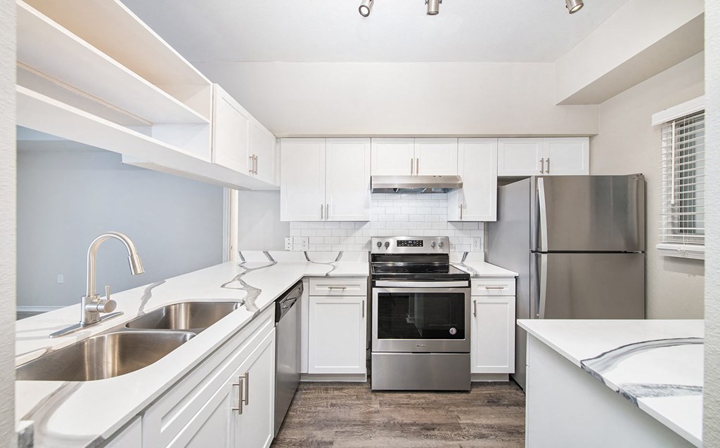 a kitchen with white cabinets and stainless steel appliances