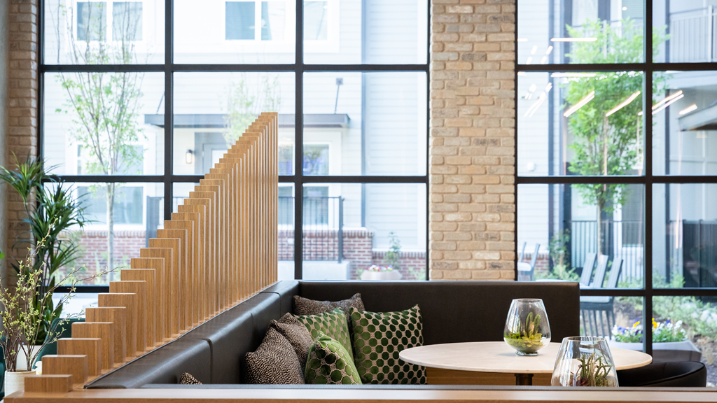 a seating area with a couch and a table in front of large windows