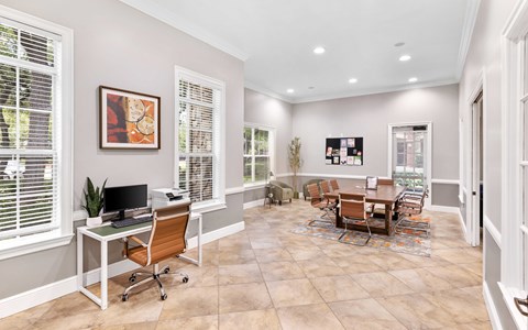 A room with a desk, chairs, and a dining table.