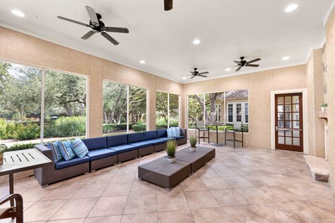 A living room with a long couch and a ceiling fan.