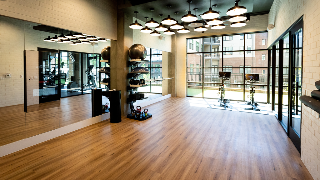 a gym with a hard wood floor and large windows