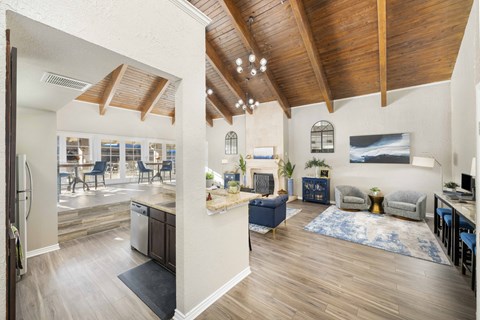 A modern open plan living and kitchen area with wooden floors and ceiling.