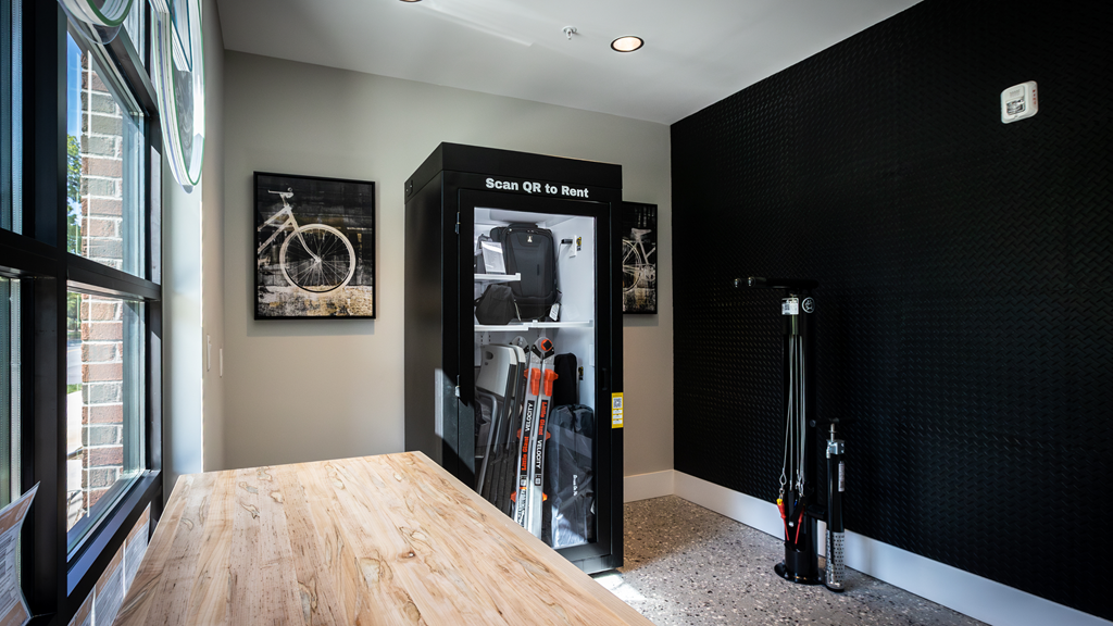 a room with a wooden table and a black wall with a refrigerator and a window