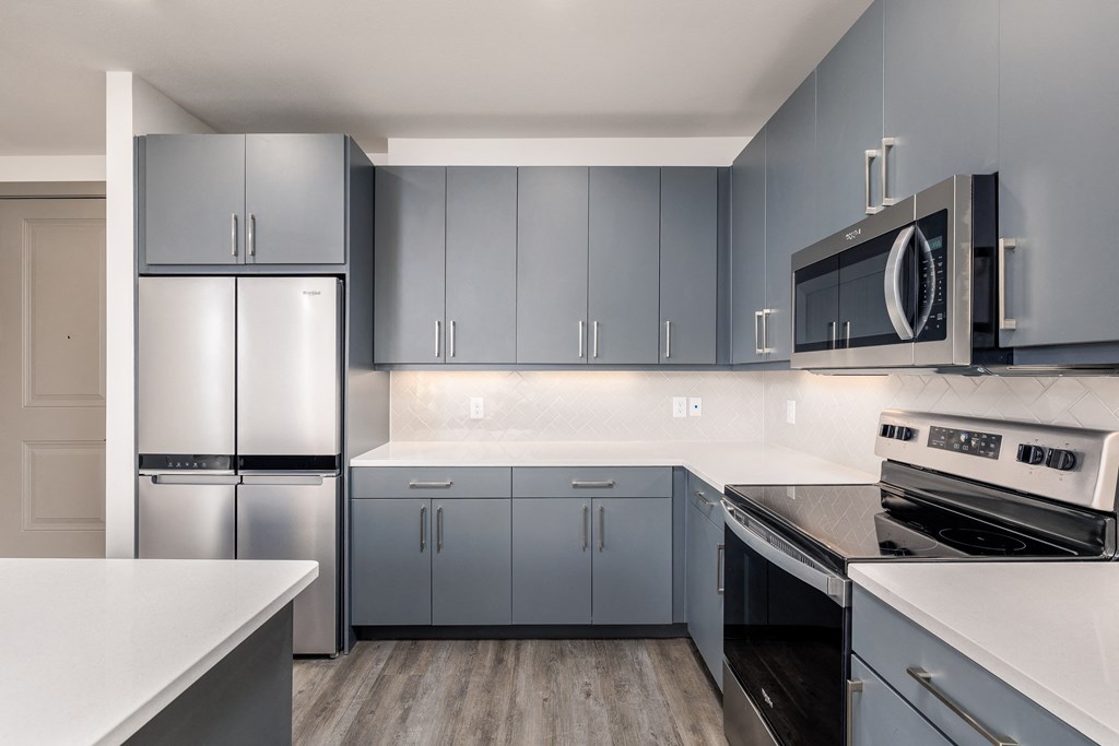 a kitchen with stainless steel appliances and white counter tops