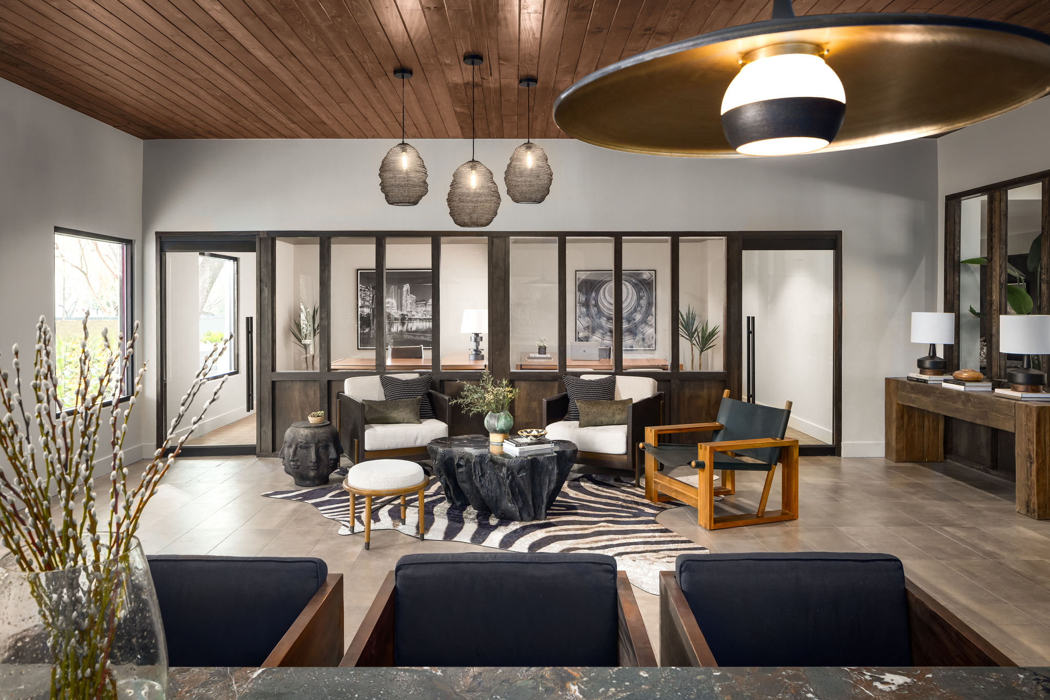 A modern living room with a zebra print rug and a wooden ceiling.