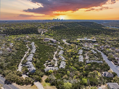 A sunset view of a residential area with houses and trees.
