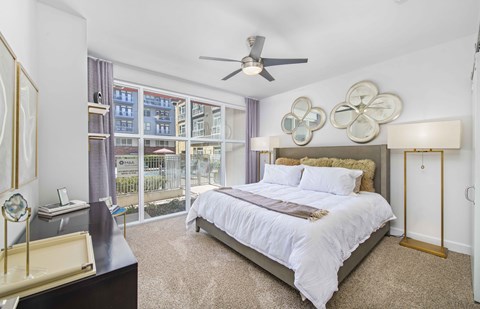 A bedroom with a large bed and a ceiling fan.