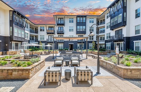 A sunny day at a courtyard with a fire pit and seating area.