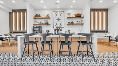 a dining area with a large table and chairs and a living room with a kitchen