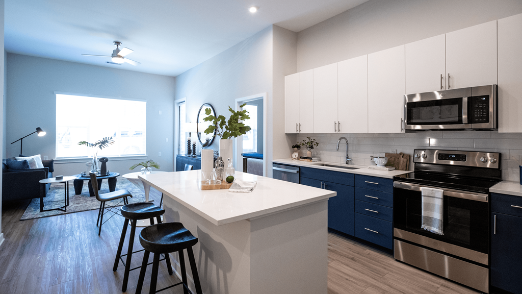a kitchen and living room with blue and white cabinets and a white counter top