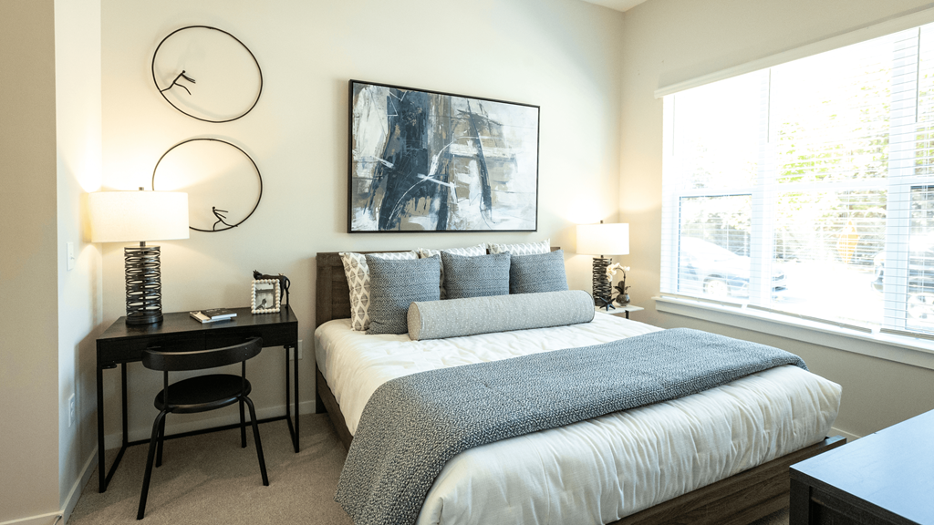 a bedroom with a bed and a desk and a window