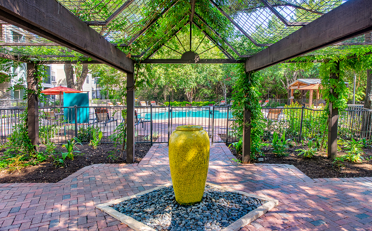 A large yellow sculpture sits in the middle of a garden.
