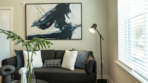 a living room with a couch and a painting on the wall
