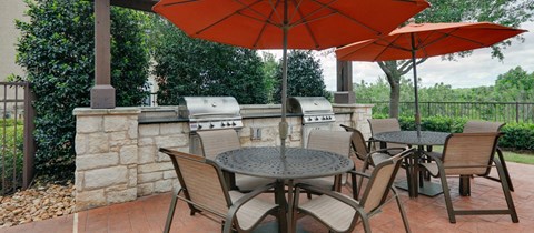 A patio with a table and chairs under an umbrella.