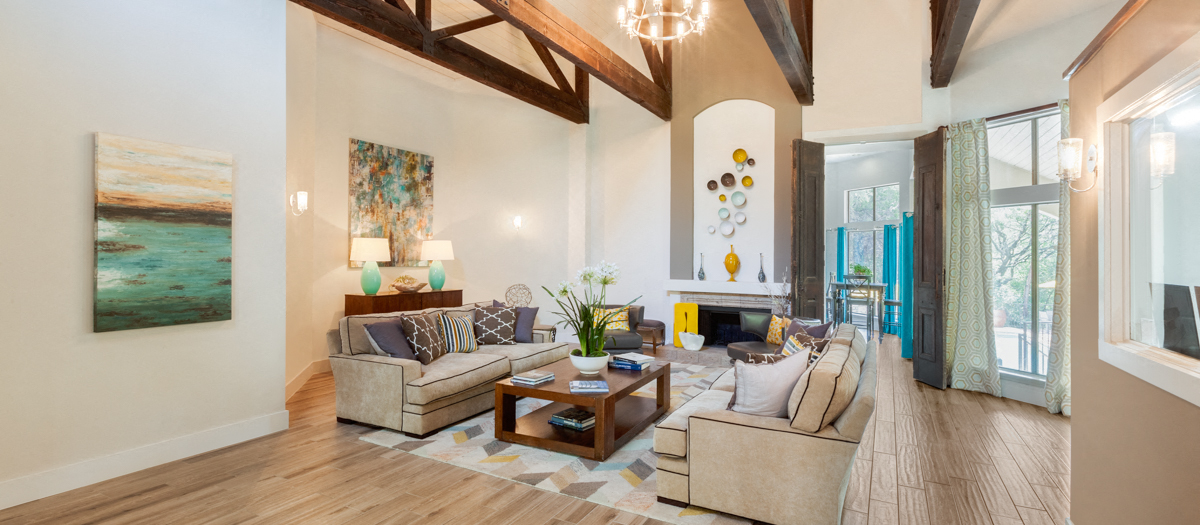A living room with a couch, a coffee table, and a painting on the wall.