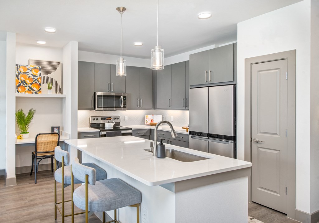 an open kitchen with a large island and stainless steel appliances