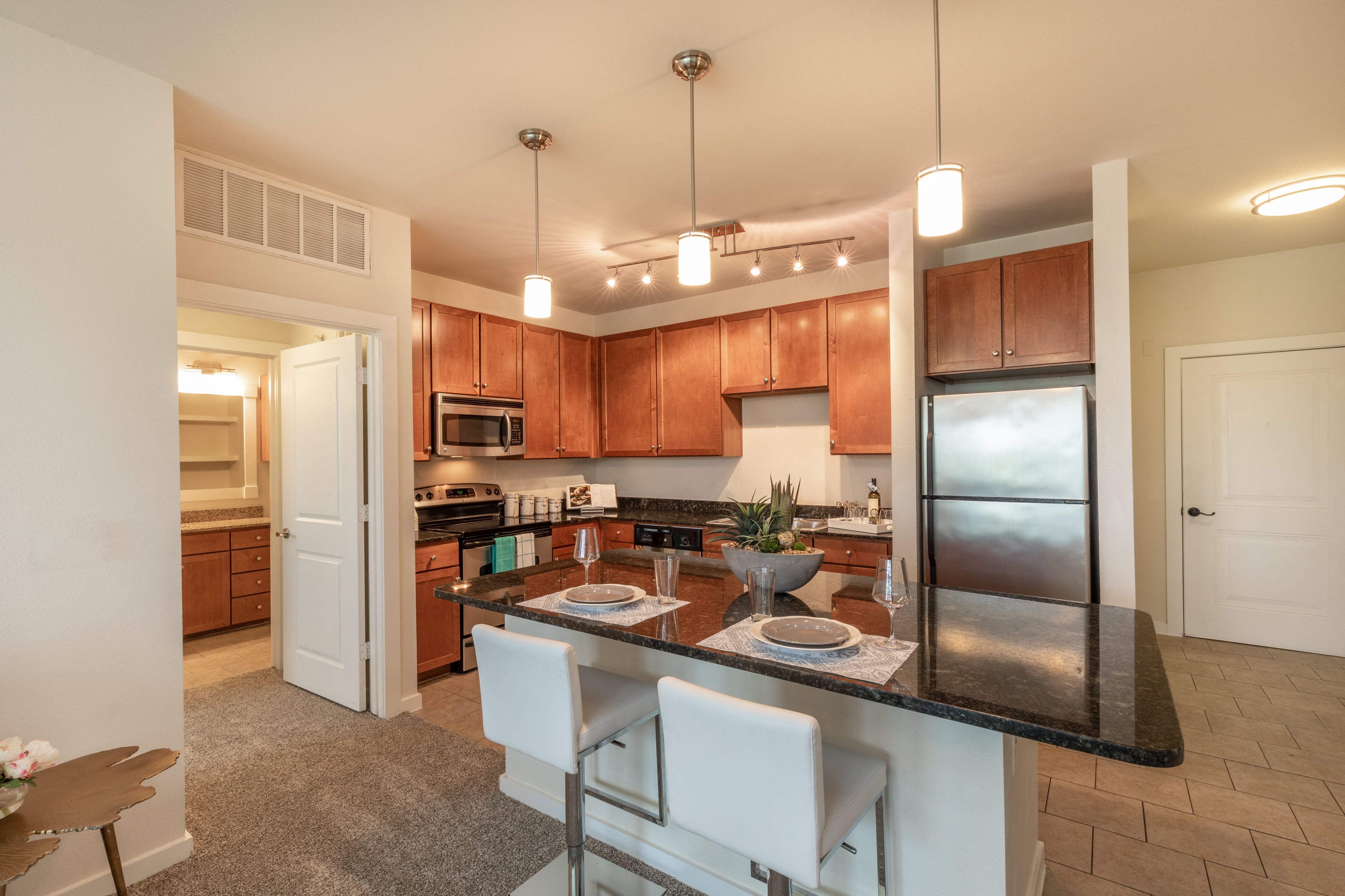 A kitchen with brown cabinets and a black countertop.