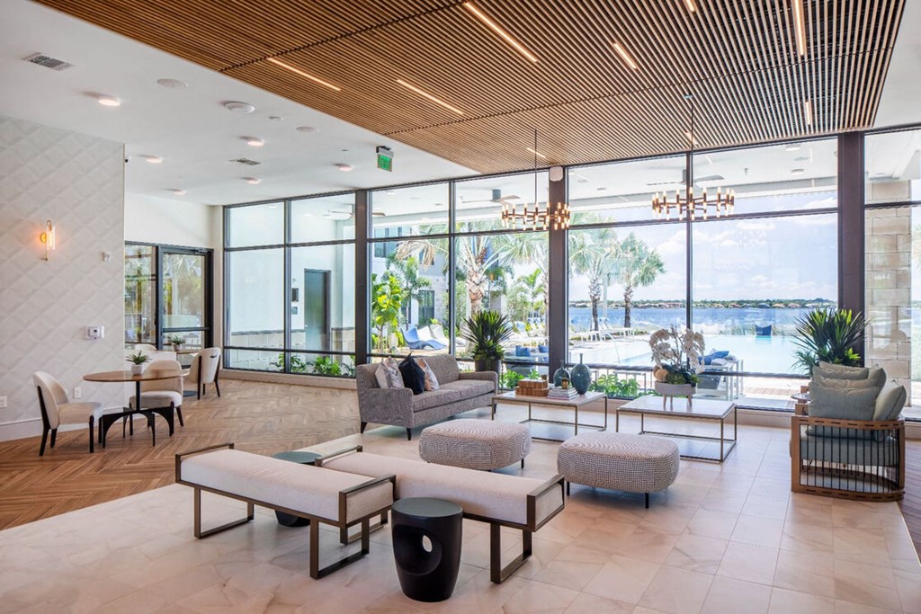 a lobby with couches and chairs and a view of a pool