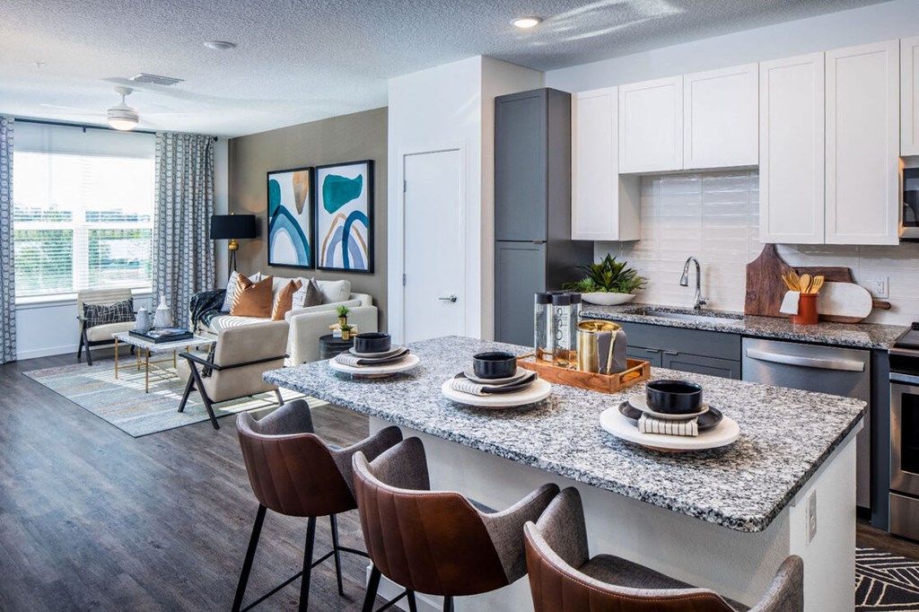 a kitchen and living room with a granite counter top