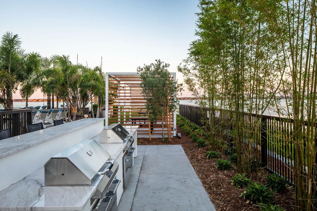 a rooftop patio with barbecue grill and trees