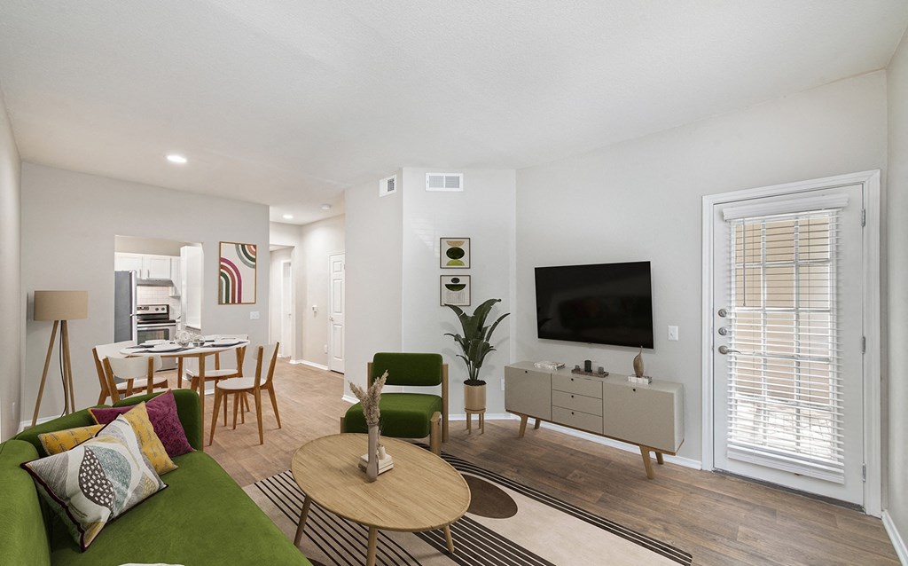 a living room and dining room with a table and a television