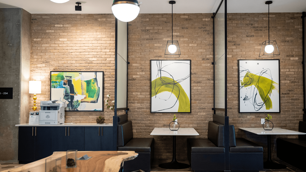 a dining room with tables and chairs and paintings on the wall
