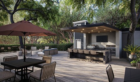A patio with a table and chairs and a grill.