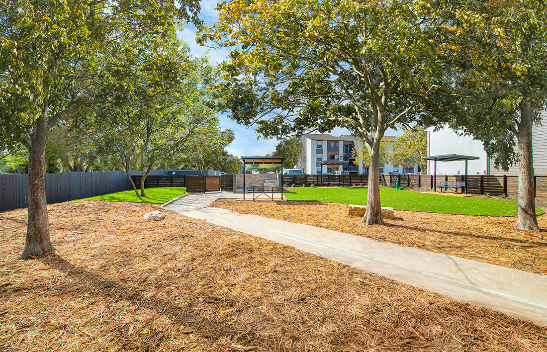 A park with a dirt path and trees.