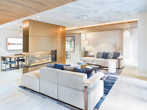 A modern living room with a large sectional sofa and a fireplace.