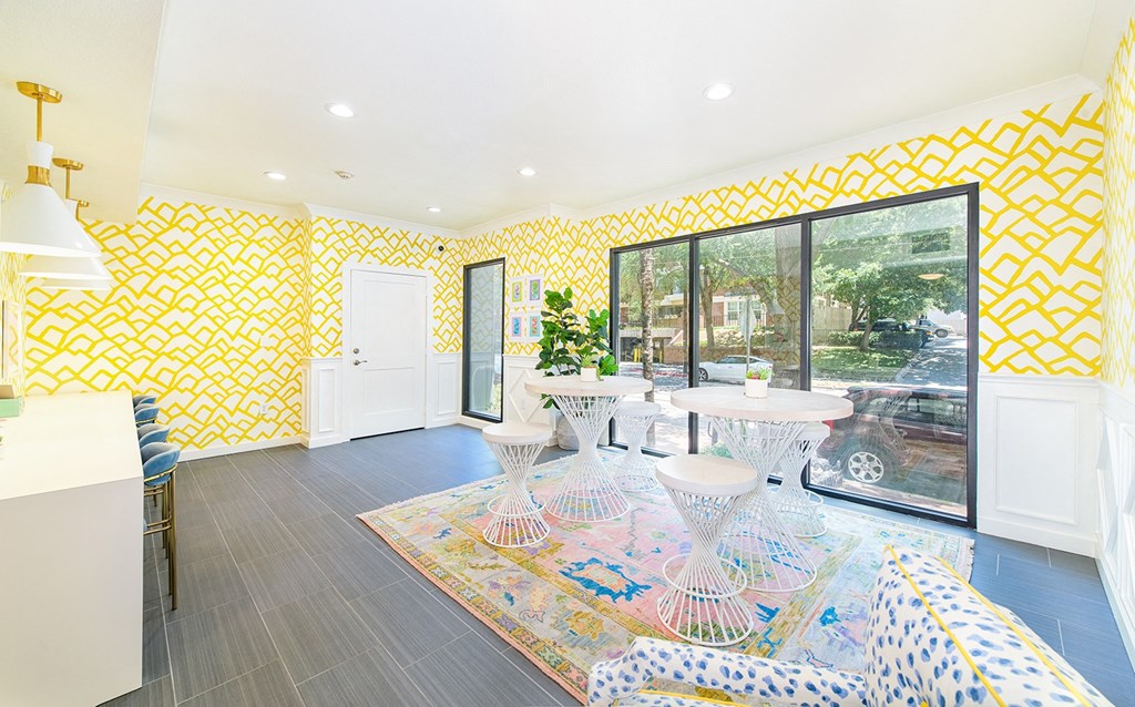 a living room with yellow wallpaper and a large window
