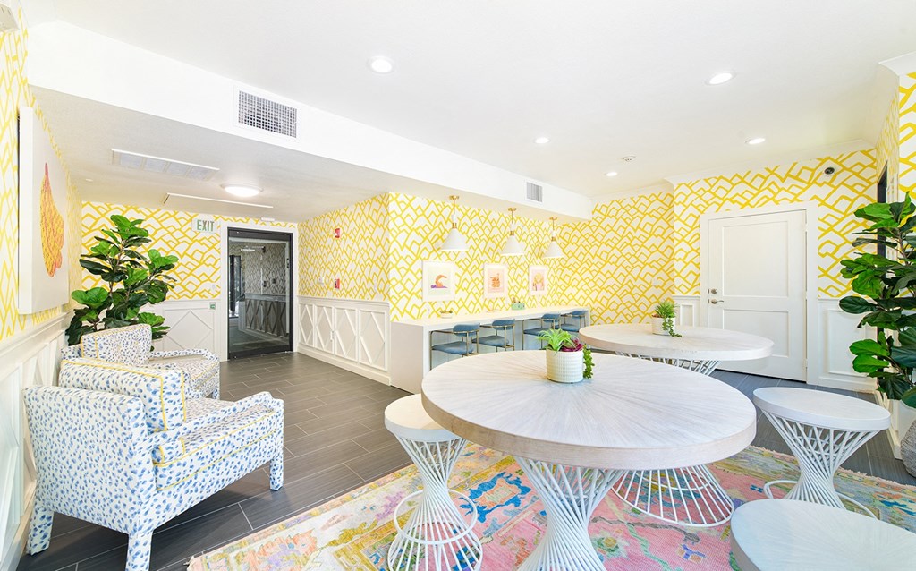 the interior of a restaurant with yellow wallpaper and tables and chairs
