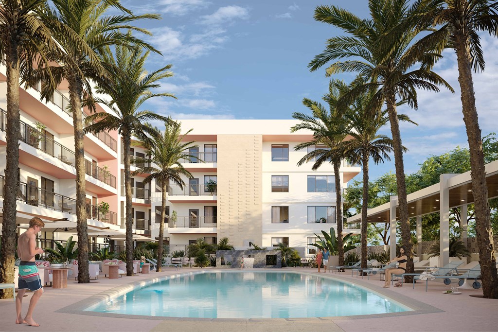 a man standing next to a swimming pool in front of a hotel