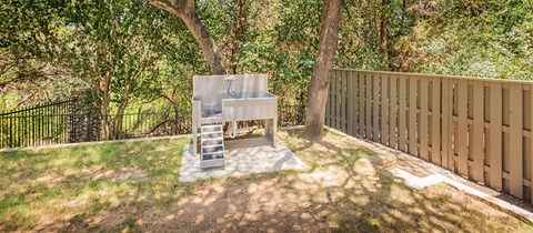 A concrete structure with steps is in the middle of a grassy area.